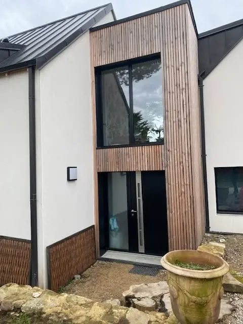Fenêtre toute hauteur, façade bardée bois